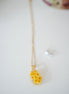 Necklace with yellow flower pendant on a white background