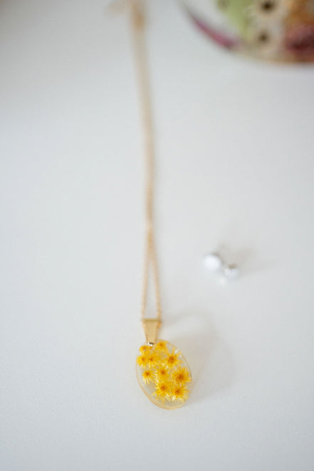 Necklace with yellow flower pendant on a white background