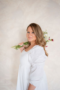 Woman holding flowers against a light background