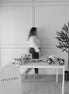 Person walking past a table with floral arrangements and 'Opal & Daisy' branding in a room.