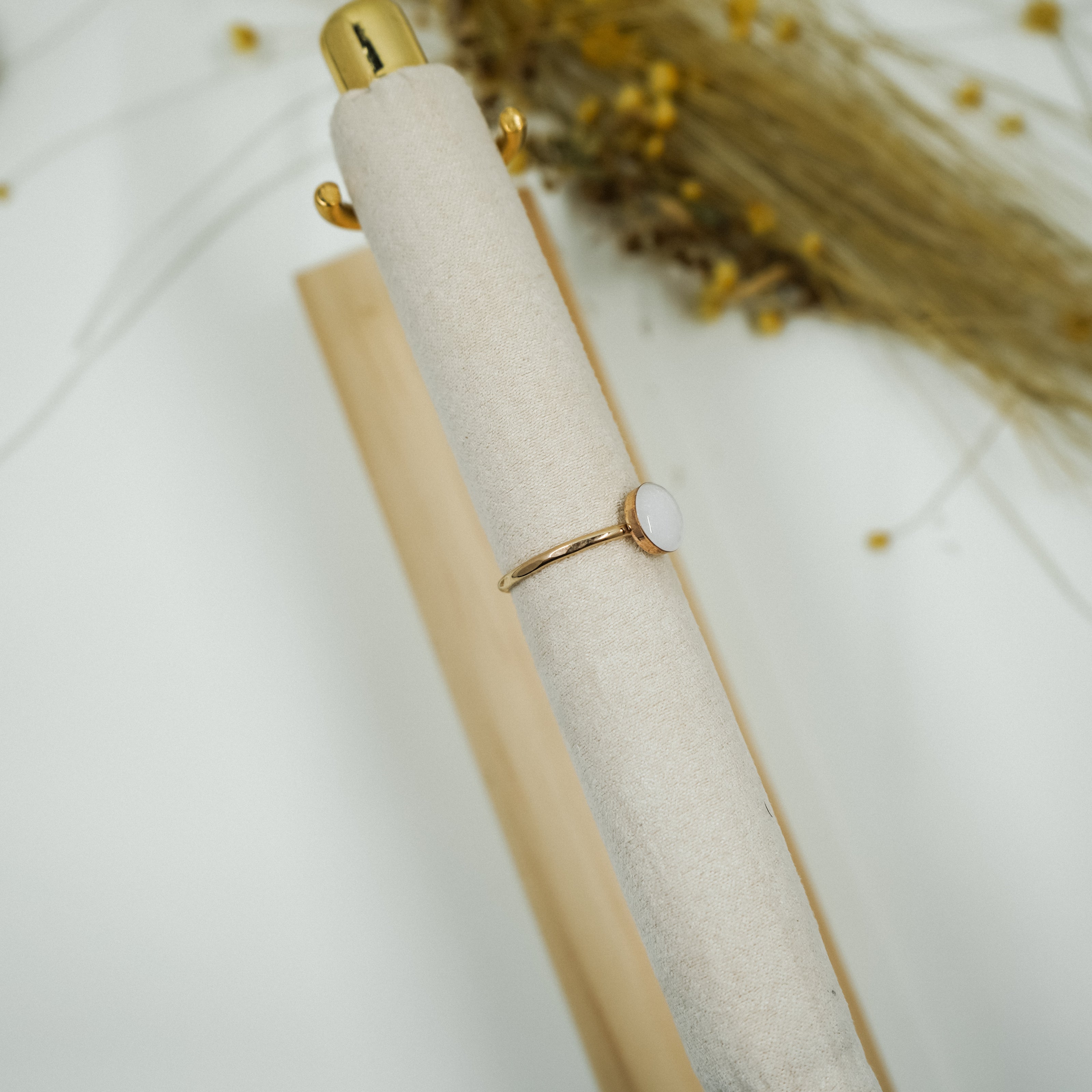 Gold ring on a white fabric surface with a blurred background